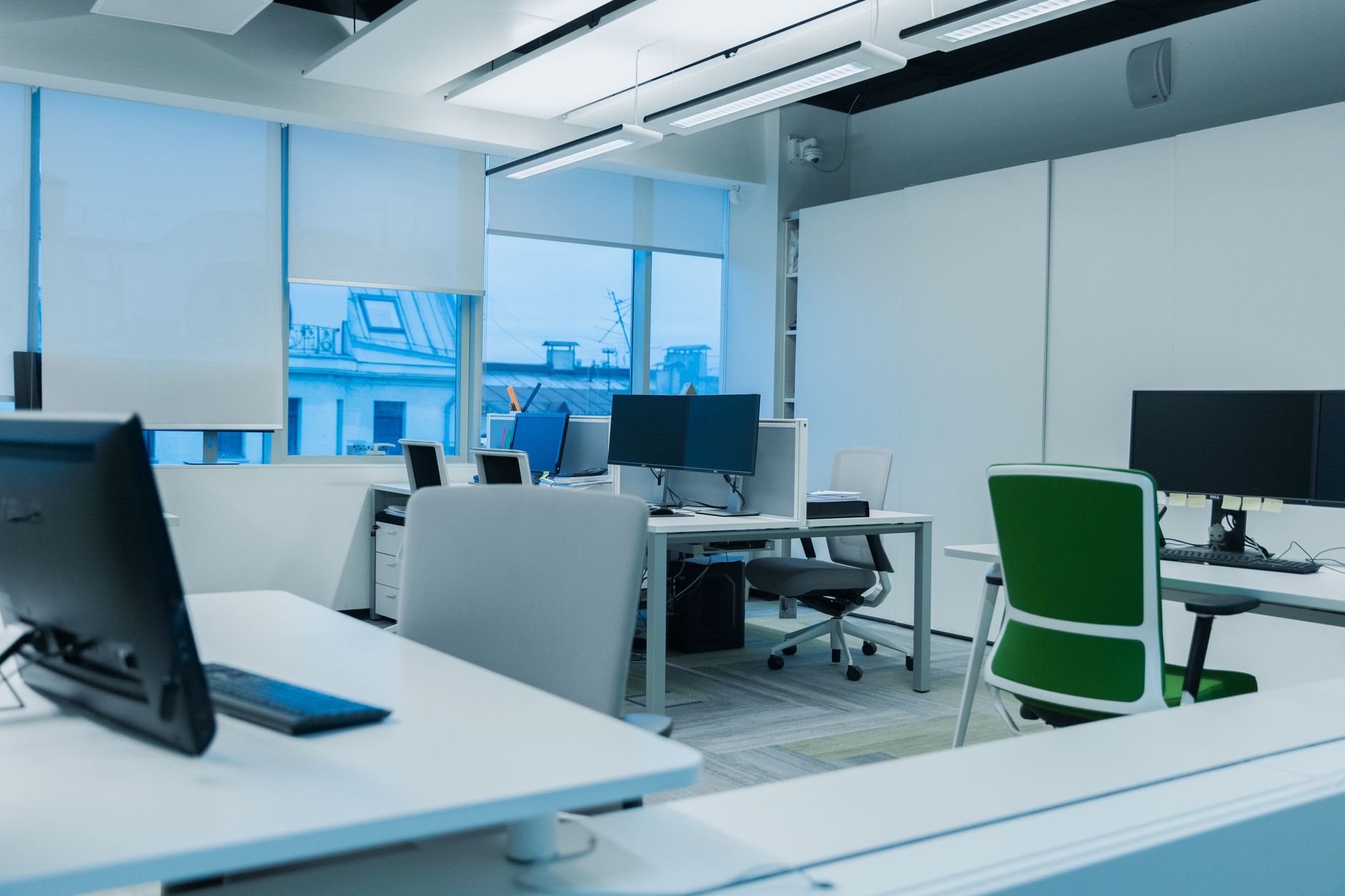 Bureau ouvert avec chaises ergonomiques réglables, postes de travail et écrans multiples