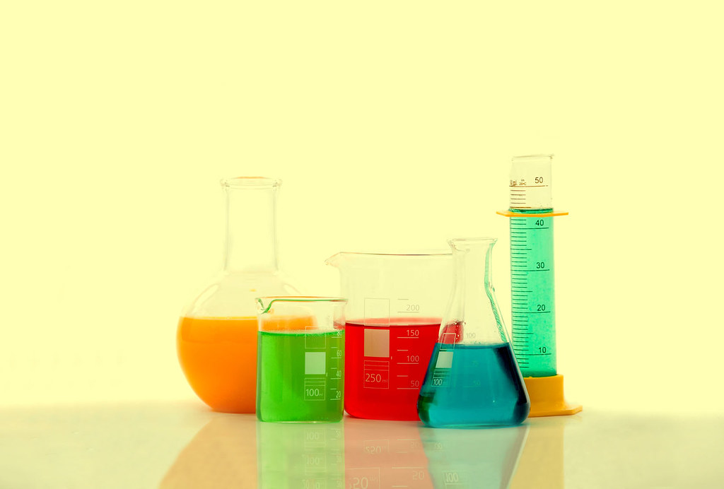 Laboratoire pharmaceutique avec flacons et verrerie illustrant l'emploi dans la pharma et le biomédical