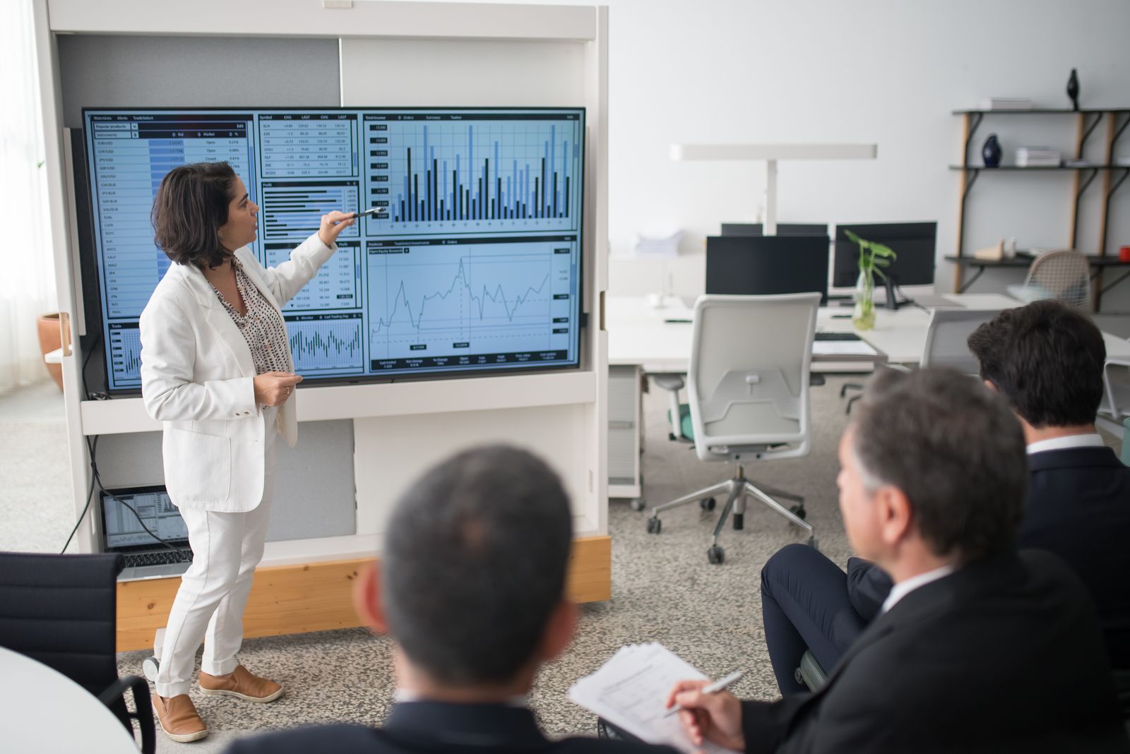 Présentation d'un tableau de bord à un auditoire de décideurs, indicateurs affichés sur grand écran